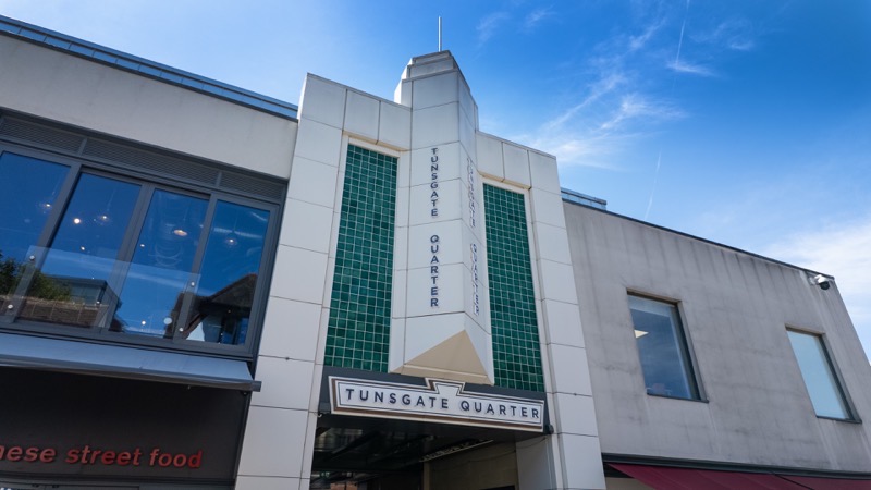 Cream art deco facade of the Tunsgate Quarter shopping centre with tall arched windows